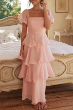 Multi-layered cake skirt with square neckline, open back, and ruffled details.